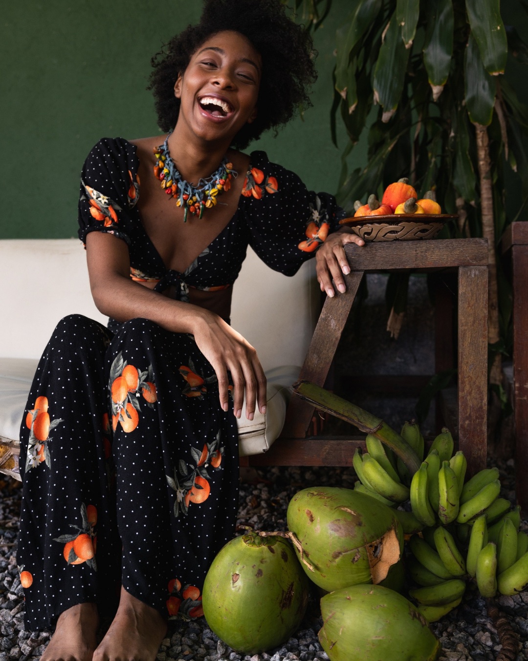Talento - Mujer afrodescendiente sonriendo junto a mesa con frutas